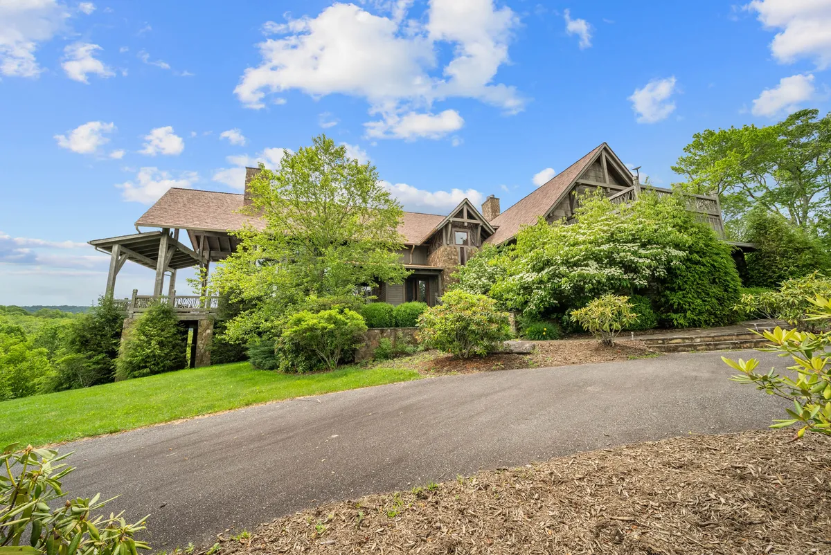 This image showcases the main entrance of Overlook at Wilderness Trail, framed by lush greenery and a gently sloping driveway. The welcoming porch hints at a tranquil retreat nestled in the mountains, offering a sense of arrival and escape from the ordinary.